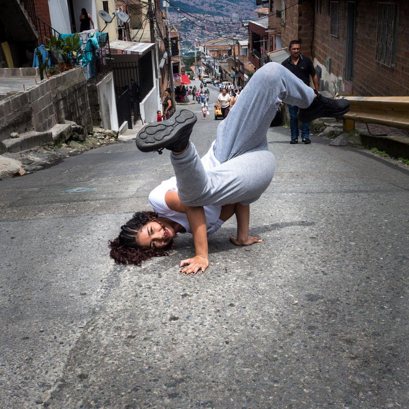 Mädchen macht Kopfstand auf einer Straße in Medellín
