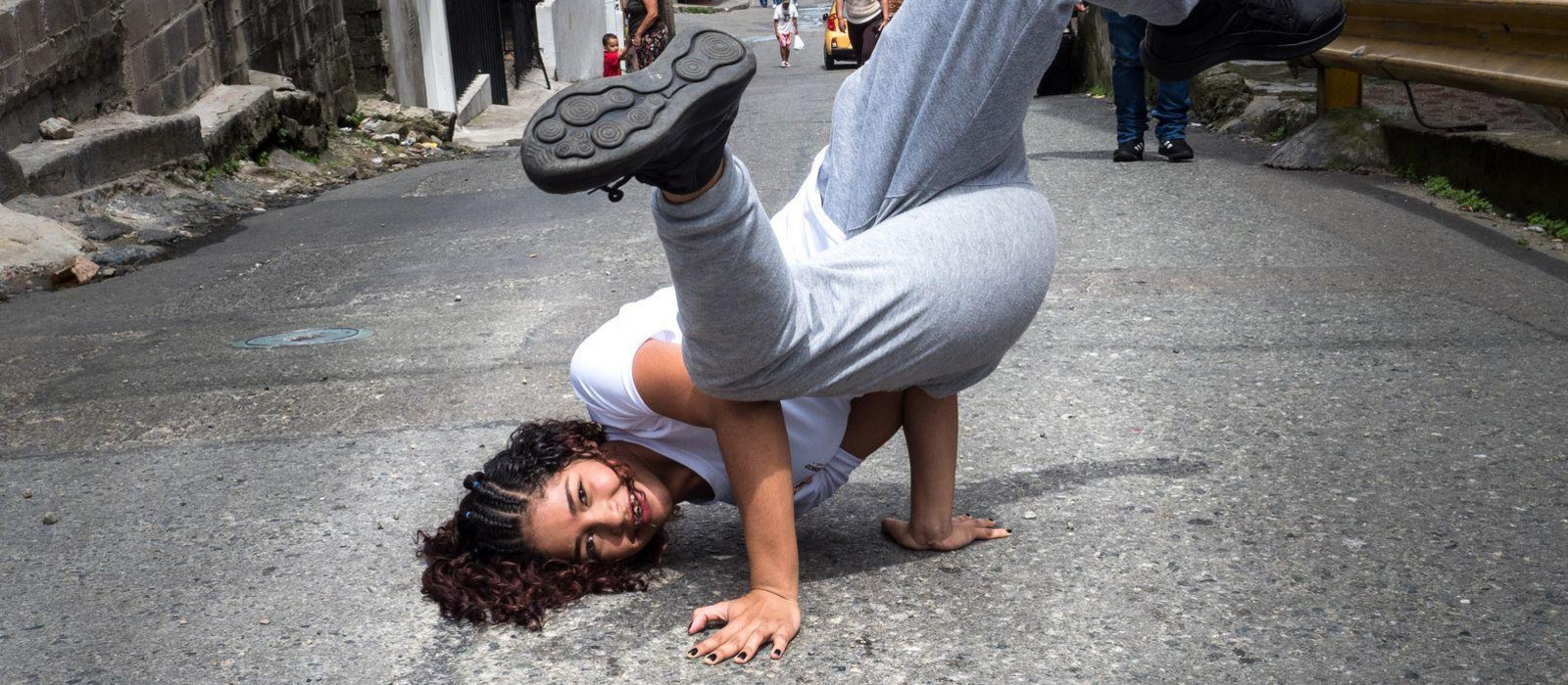 Mädchen macht Kopfstand auf einer Straße in Medellín